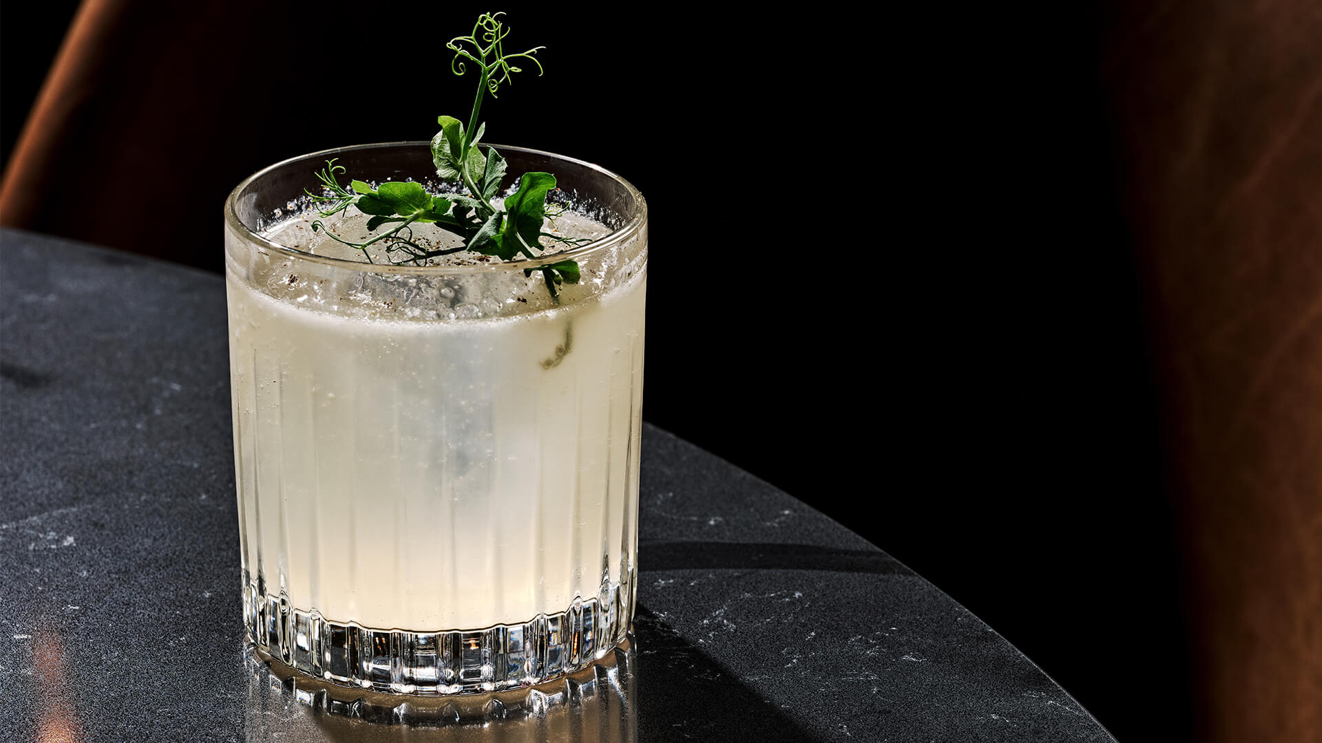 a glass with a drink and a plant on it