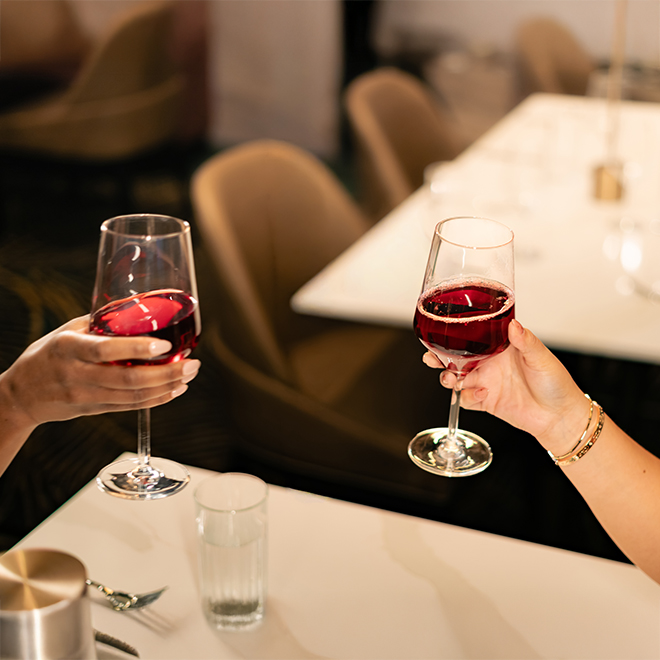 a person holding wine glasses